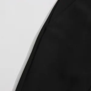 Close-up detail of black suit pants fabric showing high-quality stitching and texture