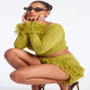 Close-up of stylish lime green knitted two-piece set featuring long-sleeve top and fringe skirt