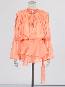 Elegant coral pleated mini dress featuring puff sleeves and a tiered ruffle hemline design