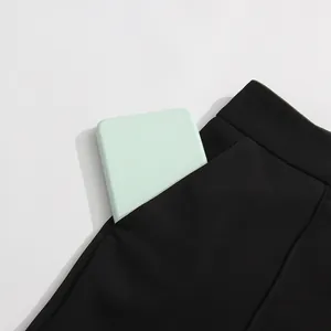 Detail view showing the functional side pocket of black flare pants with an accessory