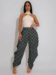 Elegant high-waisted wide-leg polka dot pants paired with a cream halter neck bodysuit top