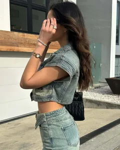Side view of woman wearing a stylish blue denim two-piece set in urban setting