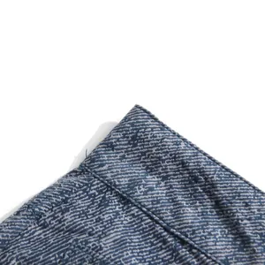 Macro detail van blauwe gradiënt denim textuur met hoogwaardige dubbele stiksels.