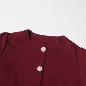 Detailed shot of burgundy round neck top featuring ornate pearl buttons for vintage set