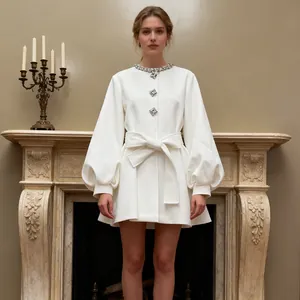 Full shot of elegant white coat with diamond buttons and puff sleeves by a fireplace
