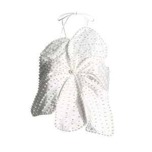 Detailed view of white flower halter top with heavy pearl embellishments and center pearl.