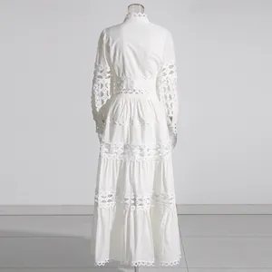 Back view of a white hollow-out tiered maxi dress with elegant lace details and long sleeves.
