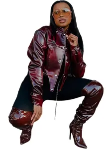 Close-up of stylish women's shiny burgundy faux leather cropped jacket and matching boots.