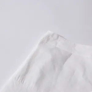 Close-up of the waistband and fine stitching on a white cotton high-waist skirt
