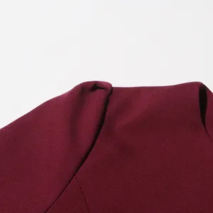 Macro detail of the fabric texture and shoulder seam of a burgundy knit top
