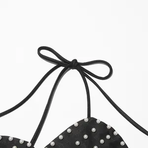 Detailed close-up of pearl bead embellishments and halter neck tie on a black tube top.