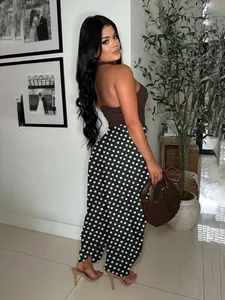 Back view of model wearing black polka dot wide leg pants and brown halter top