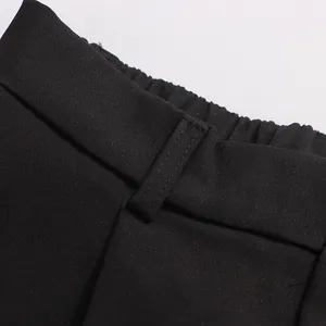 Detailed macro view of black suit trousers featuring an elastic waist and sturdy belt loops.