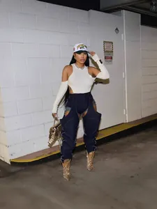 Stylish urban model wearing unique irregular cutout patchwork stretch denim pants with white top.