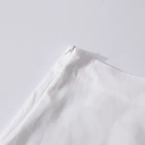 Detailed macro shot of a concealed side zipper and precise stitching on a white skirt