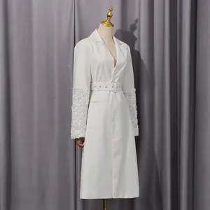 Detail des weißen mittellangen Blazers mit floralen Spitzenärmeln und Gürteltaille.