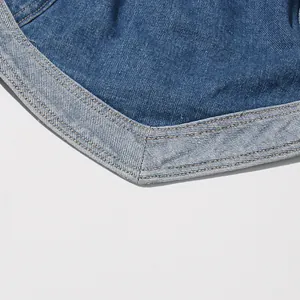 Dettaglio macro del tessuto denim lavato con patchwork a forma di cuore e cuciture