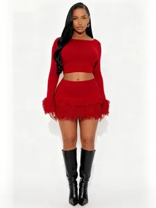 Red knit two-piece set featuring long sleeve crop top and fringe hem mini skirt