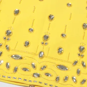 Macro view of intricate yellow beadwork and silver rhinestones on luxury garment