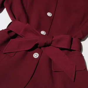Detail close-up of burgundy French vintage top with pearl buttons and tied waist