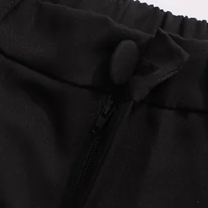 Detail shot showing the zipper and fabric-covered button on elegant black suit trousers