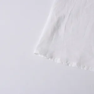 Close-up detail of white cotton fabric hem and neat stitching of this vintage style top