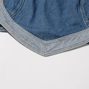 Macro dettaglio delle cuciture a contrasto e trama del tessuto del top a fascia in denim