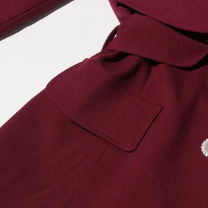 Macro view of burgundy retro court style garment detail showing waist tie and pocket flap