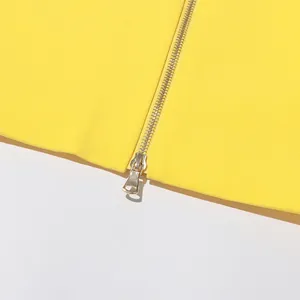 Detailed close-up of a high-quality metal zipper on a vibrant yellow designer garment