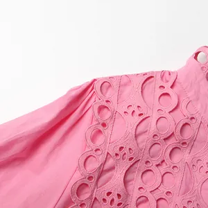 Close-up detail of intricate pink hollow-out lace embroidery on a French vintage dress
