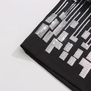Close-up of intricate silver sequin geometric embroidery on black tailored fabric