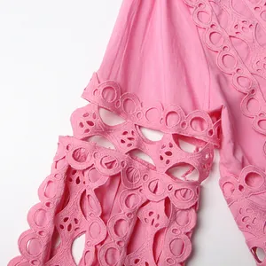 Close-up detail of pink French retro lace hollow-out embroidery on a dress sleeve.