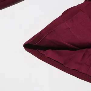 Close-up detail of high-quality stitching and fabric texture on a burgundy vintage skirt.