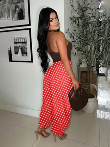 Full view of stylish red polka dot wide-leg pants styled with a brown halter top