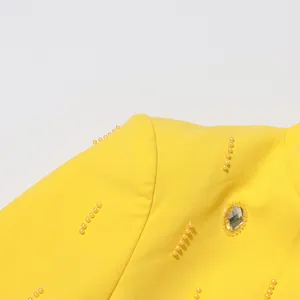 Close-up detail of yellow top featuring elegant beadwork and crystal embellishments.