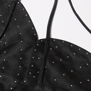 Close-up detail of black satin halter top with decorative silver stud embellishments