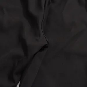 Detailed macro view of the high-quality smooth black fabric texture for the elegant suit set.