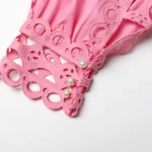 Detailed macro view of pink lace sleeve cuff featuring elegant decorative pearls