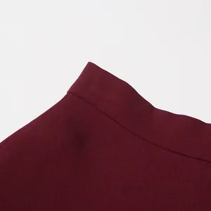 Close-up of elegant burgundy high-waisted skirt waistband showing fabric texture