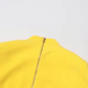 Close-up detail of high-quality golden back zipper on elegant bright yellow top