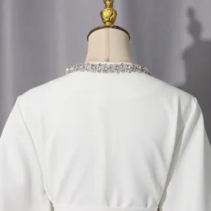 Close-up of elegant white jacket collar featuring intricate sparkling rhinestone detail