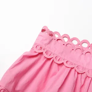 Close-up detail of the intricate scalloped lace edging on a pink vintage French style dress