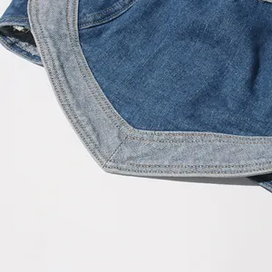 Primo piano del patchwork a cuore sul top a fascia in denim lavato vintage.
