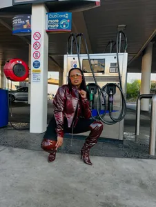Stylish cropped burgundy patent leather jacket with matching high boots