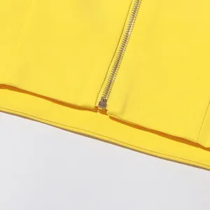 Detail view of a yellow designer top with a durable metal zipper and clean stitching.
