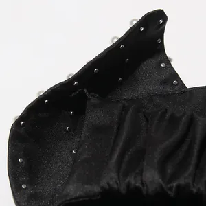 Detailed close-up of silver studs and beads on black satin halter neck tube top
