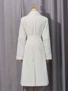 Eleganter weißer mittellanger Trenchcoat mit floralen Applikationen und Taillengürtel.