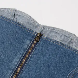 Dettaglio ravvicinato della zip metallica su un top a fascia in denim lavato vintage.