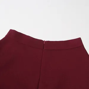 Detailed macro view of burgundy high-waisted skirt featuring a hidden back zipper closure