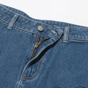 Detailansicht des Taillenbereichs mit Reißverschluss und Metallknopf einer blauen Jeans